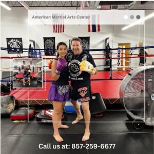 Young female boxer with coach in boxing gym at American Martial Arts Center.