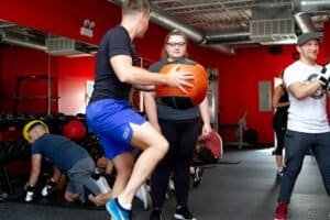Young man practicing boxing with a medicine ball in gym.