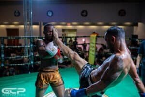 Muay Thai fighters practicing in a boxing ring during training session.