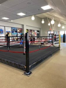 Indoor boxing ring with young fighters training at Starrett City Boxing.