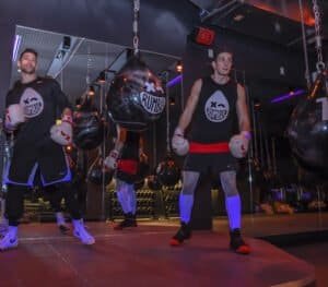 Boxers training with punching bags at Rumble Boxing gym.
