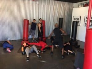 Group boxing training session with trainers and students at a gym.