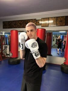 Young male boxer in training with gloves at Fight Factory MMA gym.