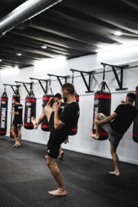 Young fighters practicing kickboxing techniques in gym.