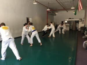 Students practicing Jiu-Jitsu techniques in a training session.