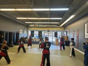 Children practicing martial arts in a spacious dojo at Legacy Martial Arts RI.
