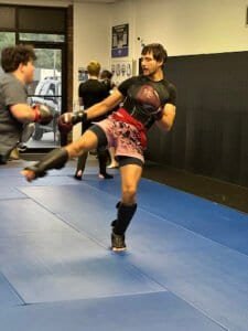 Martial arts training at Warrior Academy with sparring and kicks.