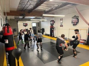Boxers practicing sparring and training in a boxing gym.