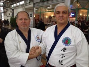 Two martial artists shaking hands at Tang Soo Do event.