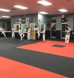 Children practicing Taekwondo kicks in a martial arts class at Oxford Karate Institute.