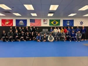 Group of martial artists at Black Bear BJJ & Fitness dojo with flags.