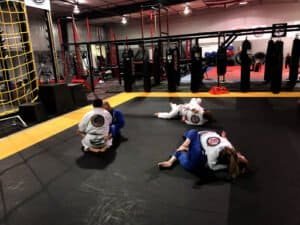 Brazilian Jiu-Jitsu students practicing techniques on mats at Tech MMA & Fitness.