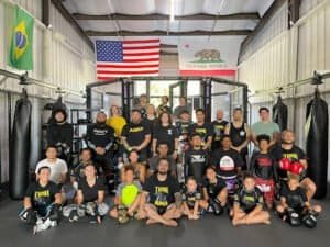 Group photo of Tusk MMA fighters and trainers in gym.