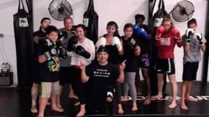 Group of young boxers with coach in gym, ready for training.