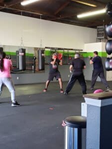 Boxing class with students practicing punches in gym.