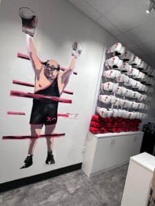 Wall mural of a boxer with boxing gloves and a rack of boxing gear.