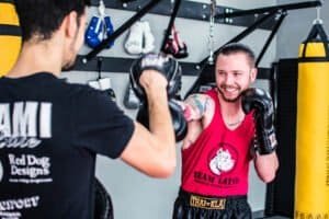 Boxer practicing punches with trainer at Juniper Muay Thai Gym.
