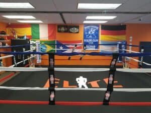 Boxing ring inside Elite Boxing & Fitness Academy with flags and banners.