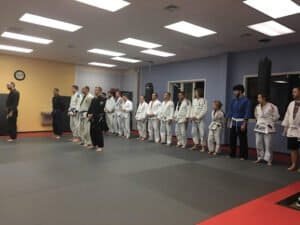 Students in martial arts uniforms lined up in training room at York MMA Academy.