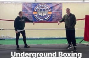 Two boxers in training at Underground Boxing Gym with logo in background.