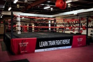 Boxing ring inside Teknique Boxing gym with training slogans.