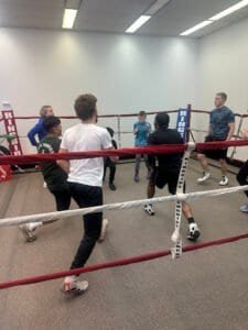 Group of young boxers training in a boxing gym with coach at Obey Boxing Elite.