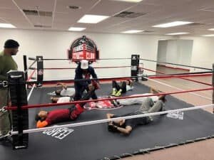 People practicing boxing exercises in a training ring at Fears Boxing and Fitness Club.