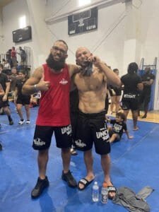 Two fighters celebrating after training at Unchained Fitness MMA gym.