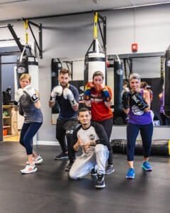 Group of diverse boxers training with punching bags at Final Round Gym.
