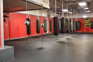 Row of punching bags in a boxing gym for training and fitness.