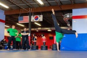 Martial arts students practicing handstands and drills in a gym.