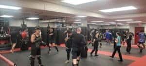 Group of people practicing boxing techniques in a gym.