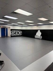 Indoor martial arts training area with SBG West Virginia branding.