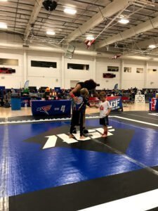 Kids and coach practicing boxing techniques at indoor gym.