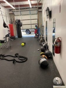 Boxing gym with punching bags, medicine balls, and training equipment.