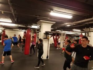 Boxers training in Portland City Boxing gym with punching bags and trainers.
