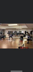 People training in a boxing gym with mirrors and boxing equipment.