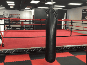 Heavy punching bag in boxing gym for training and fitness.