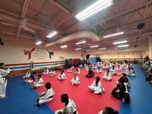 Kids practicing martial arts in a spacious gym at American Martial Arts Academy.