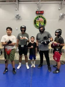Young boxers and trainers in boxing gear at Boa Luta Academy gym.