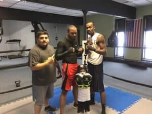 Group of boxers training in gym with boxing gloves and equipment.