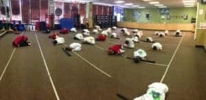 Children practicing martial arts in a spacious training room.