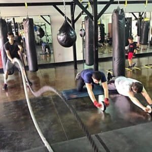 Boxing students training with ropes and punching bags at Ramos Boxing Academy.