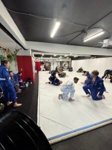Kids practicing Brazilian Jiu-Jitsu techniques on mats at Neutral Ground Academy.