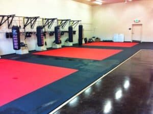 Boxing training area with punching bags and mats at NAK2 Academy.