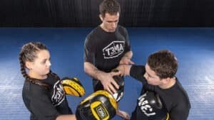 Young boxers practicing with coach during training at Redmond gym.