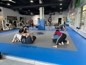Students practicing Jiu Jitsu techniques on mats at Renzo Gracie Sammamish gym.