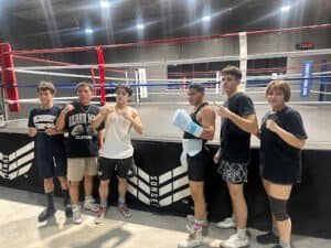 Group of young boxers in training at sunset boxing gym.