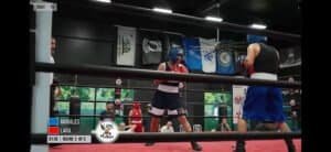 Two boxers sparring in a boxing ring during a match at Tzintzun Boxing and Fitness.