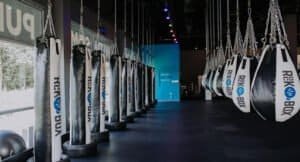Indoor boxing gym with hanging punching bags at Rockbox Fitness Greer.